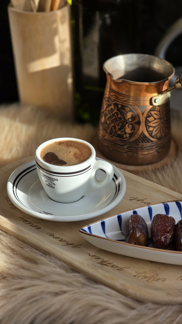Freshly brewed Turkish coffee in a traditional copper pot served with dates, highlighting Lily’s Chocolates & Café’s global coffee inspirations.